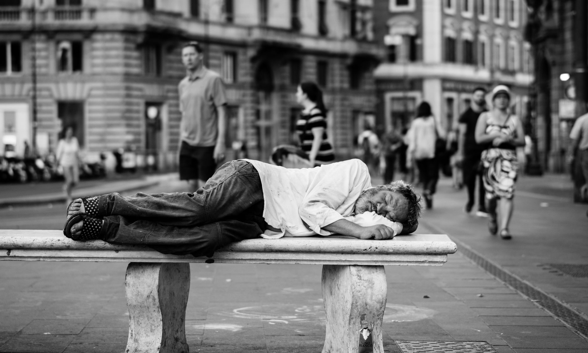 Un homme dors sur un banc